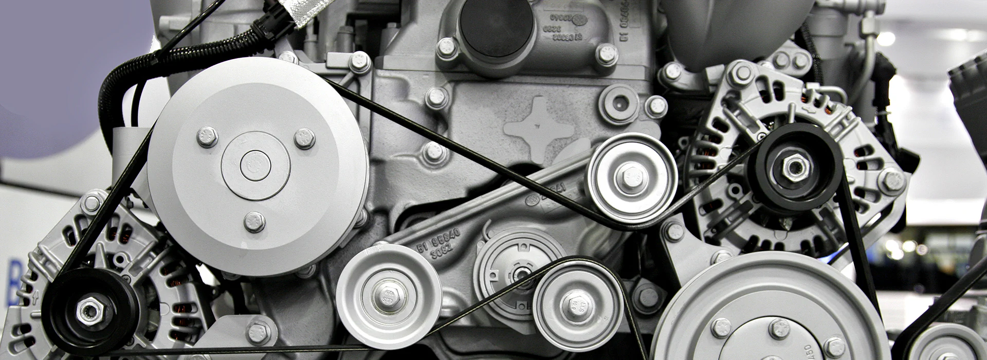 Bildbeschreibung / description: Detailaufnahme eines Motors: Sicht auf metallische Bauteile, Rohre und Verschraubungen in einem komplexen technischen Aufbau.